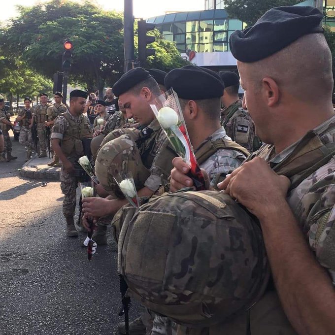 People are distributing flowers at the Lebanese Army during the protests in Saida southern Lebanon