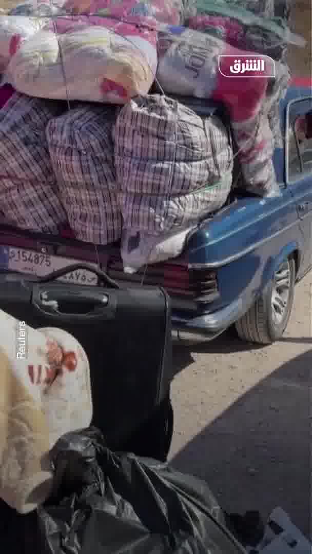 Displaced people from Lebanon head to the Al-Masnaa border crossing with Syria on foot after an Israeli raid cut off the road leading to it