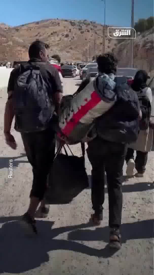 Displaced people from Lebanon head to the Al-Masnaa border crossing with Syria on foot after an Israeli raid cut off the road leading to it