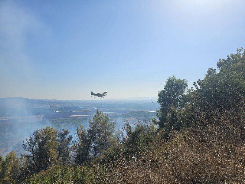 שירותי החירום הישראליים משתמשים בכלי טיס לכיבוי שריפה שפרצה בהתנחלות שלומי לאחר שטיל חיזבאללה פגע בה.